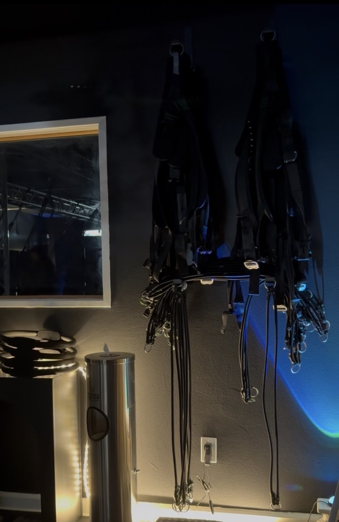 The harness and cord storage wall with sanitizer station at BUNGE Fitness in Huntington Beach