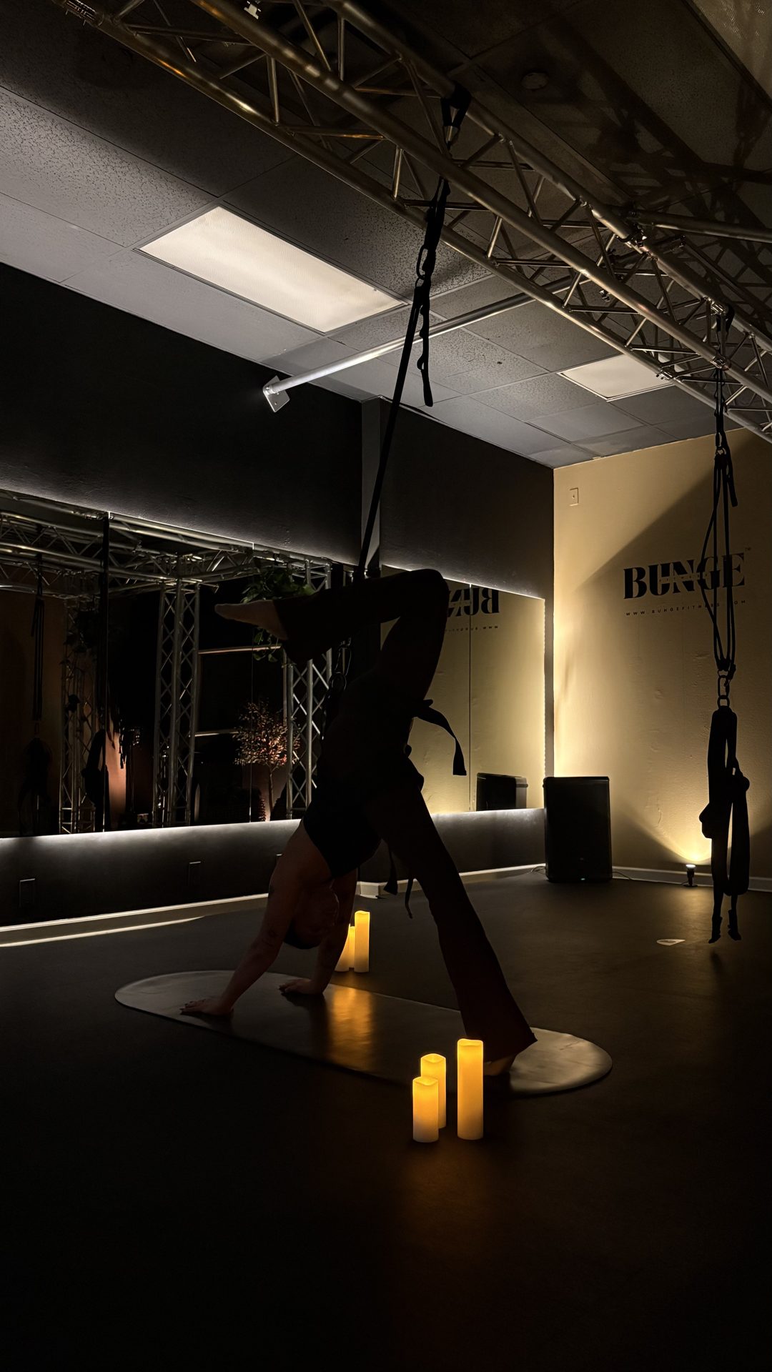 A stretch silhouette in low candlelight at BUNGE Fitness in Huntington Beach
