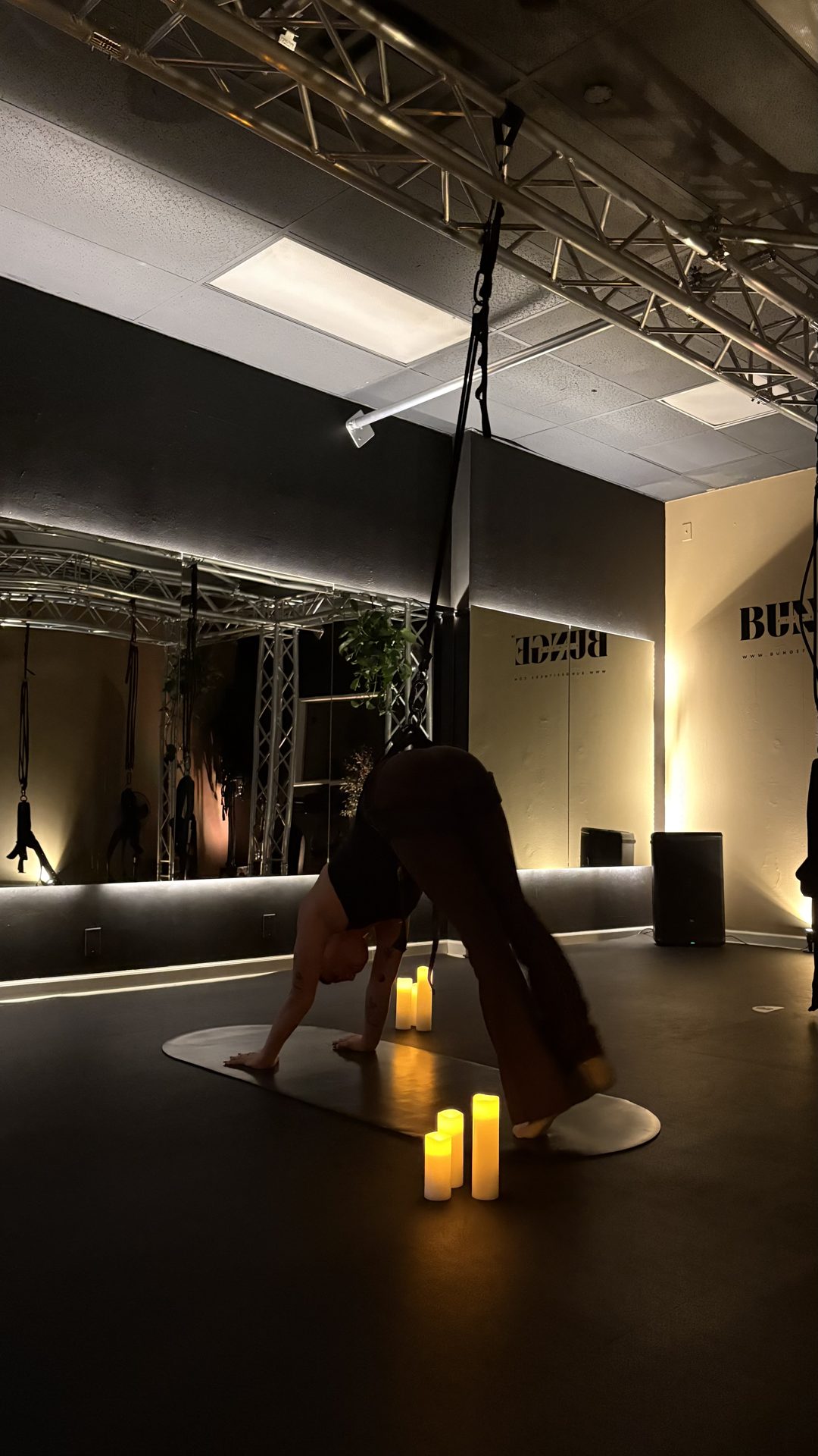 Students in a candlelit cooldown during a bungee fitness class at BUNGE Fitness